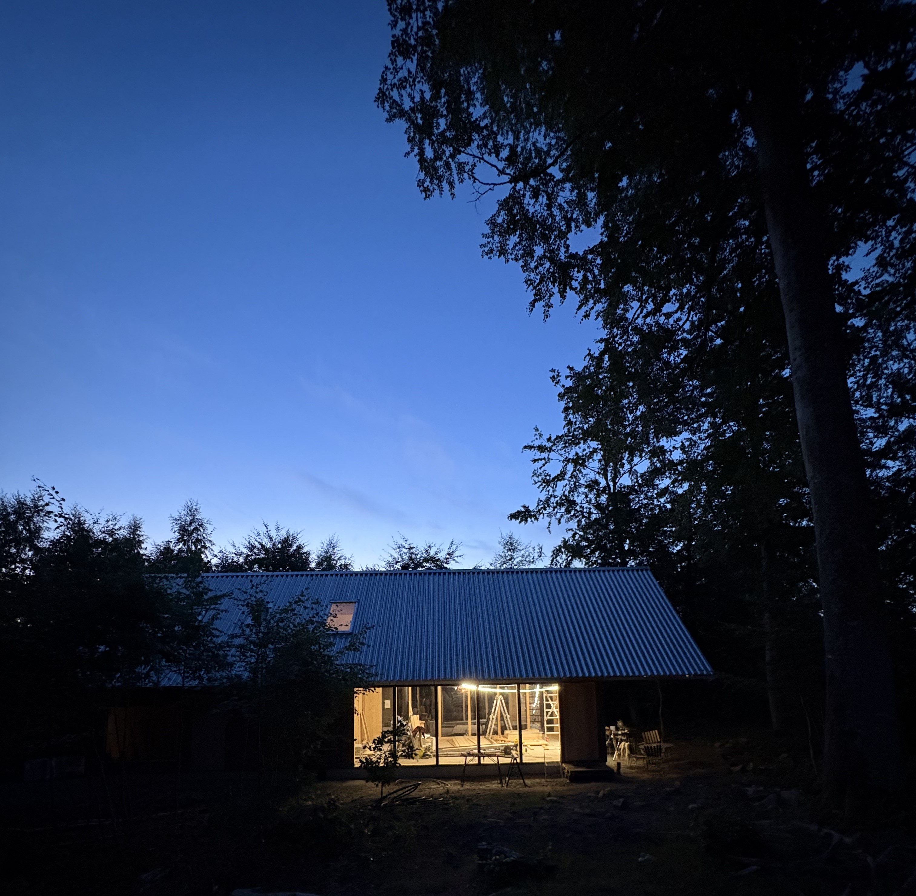 Beech House upplyst i bokskogen i skymningen